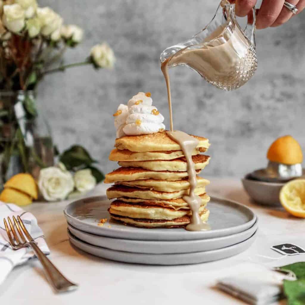 Lemon pancakes with anglaise being poured over top