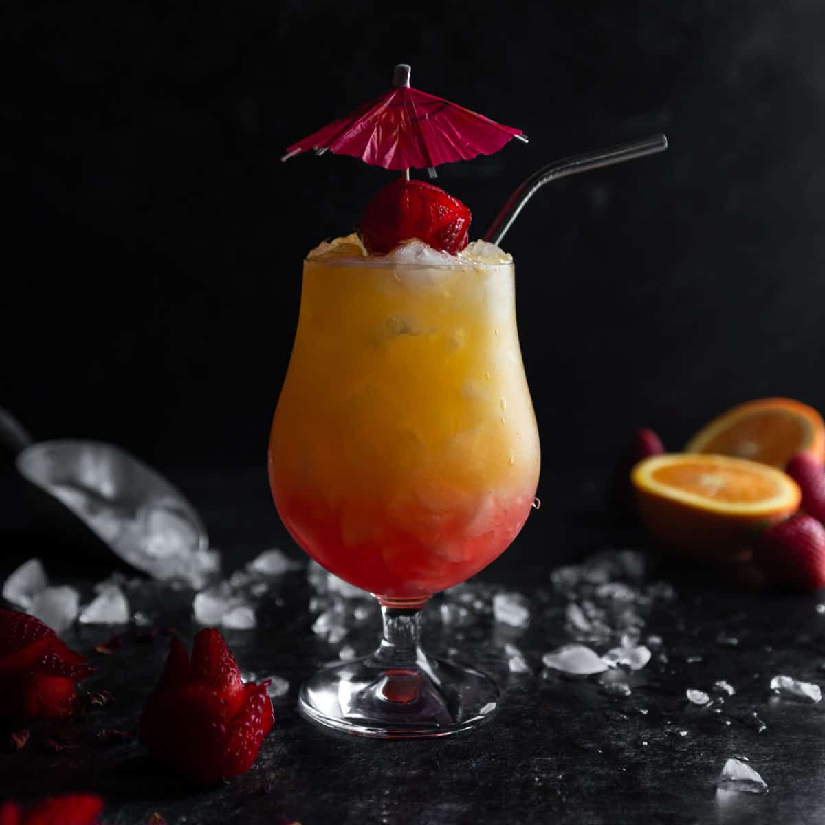 Strawberry Rose Tequila Sunrise garnished with an umbrella