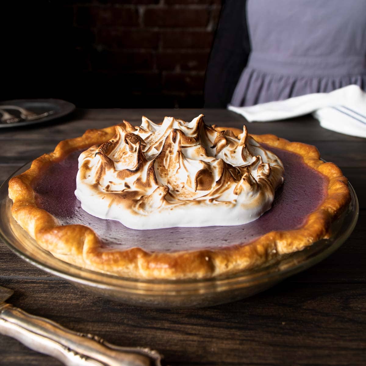 A purple sweet potato pie topped with a torch Swiss meringue