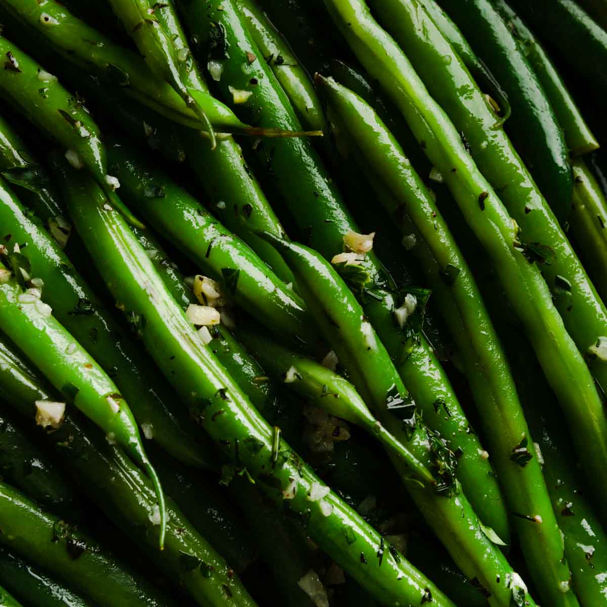 A close up image of haricot verts in garlic herb butter