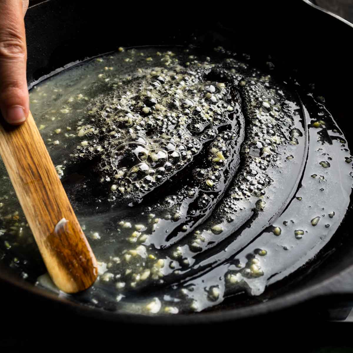 Sautéing butter and minced garlic in a large cast iron skillet