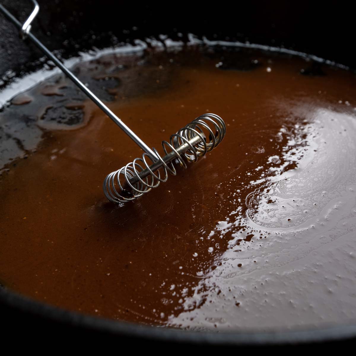White wine pan sauce being whisked in cast iron. 