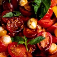 A macro shot of cherry tomato capers salad with mozzarella and balsamic