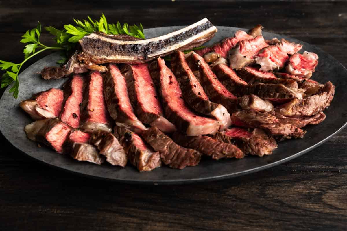 A platter of medium rare grilled ribeye steak