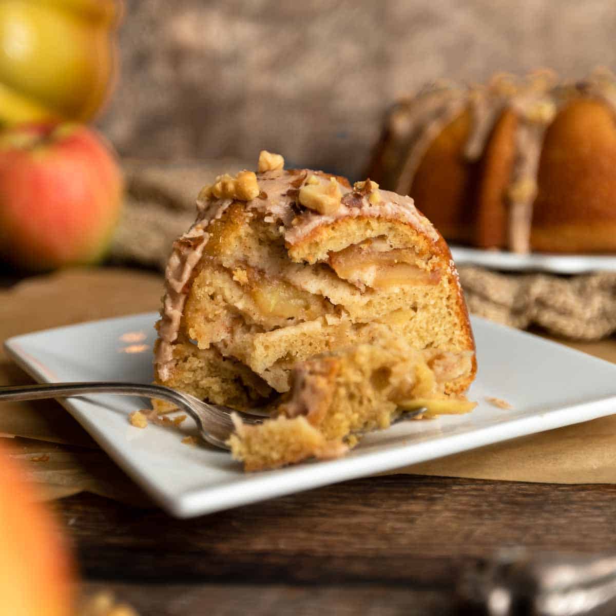 A slice of apple cake and a big forkful