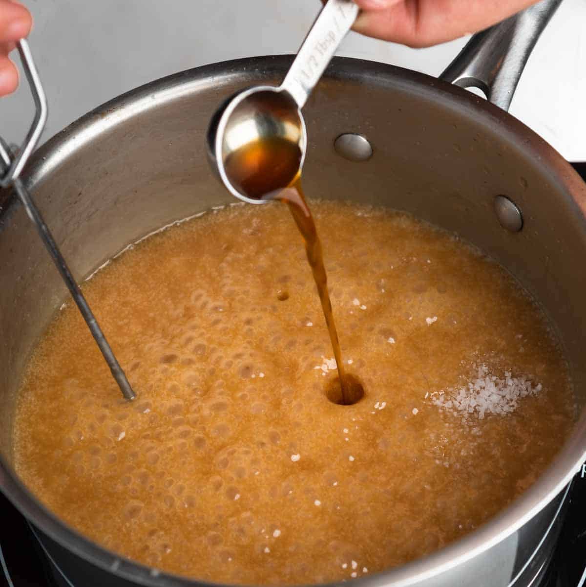 Stirring salt and vanilla into a glossy caramel sauce