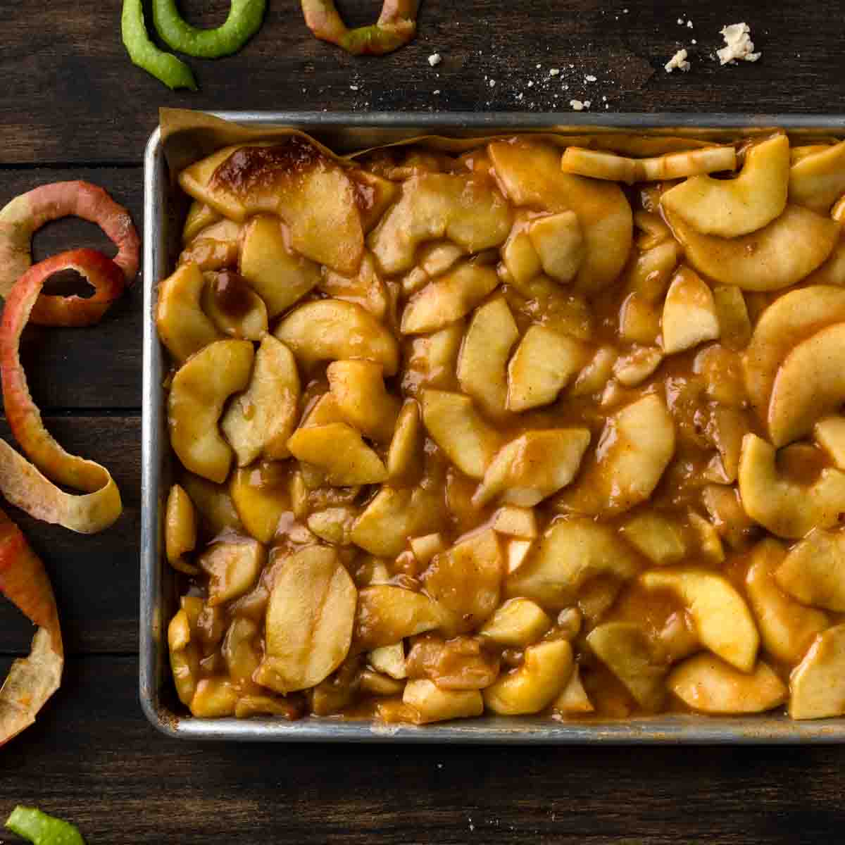 Cooked apple pie filling chilling on a quarter sheet tray