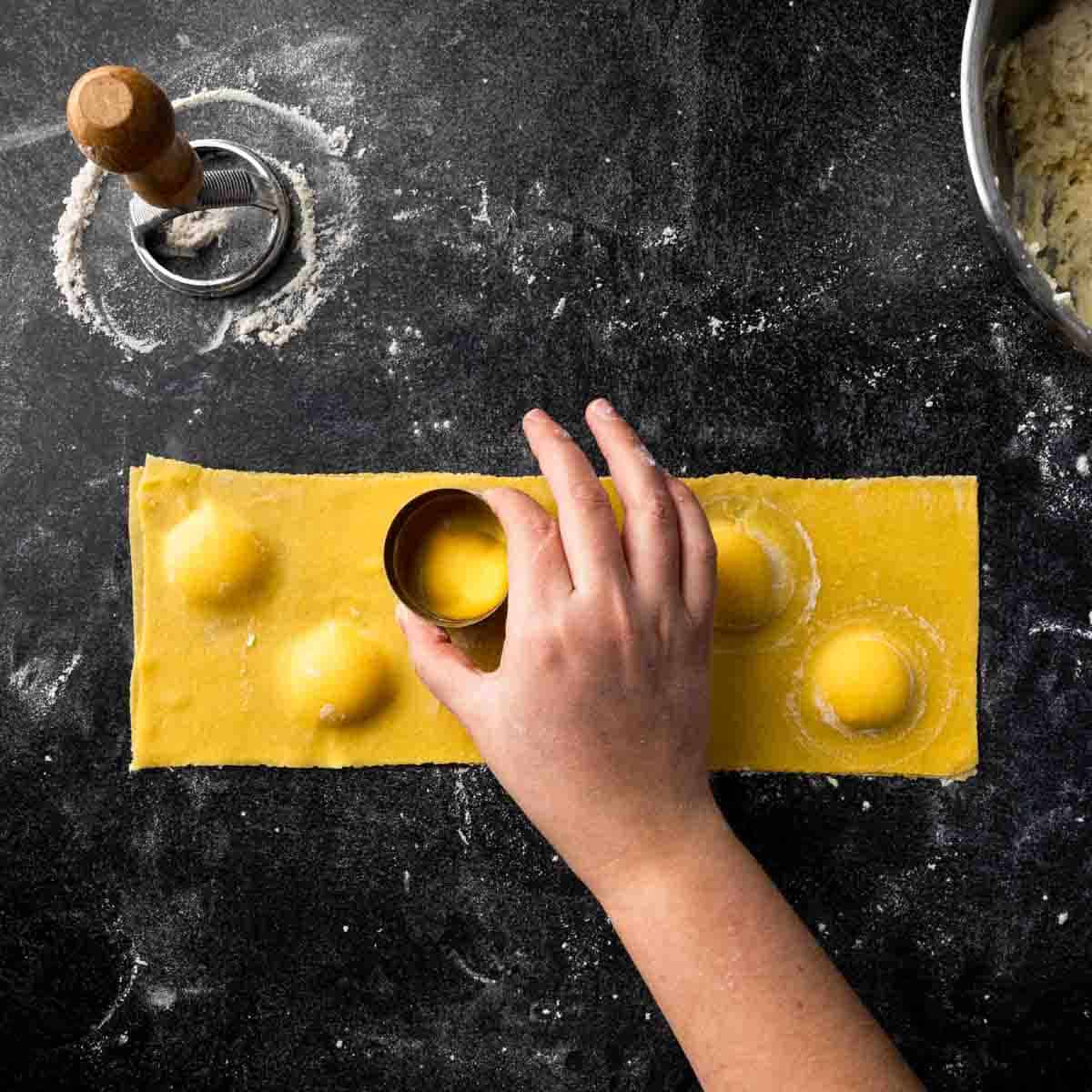 Using a cookie cutter to shape the ravioli filling into a perfect circle.