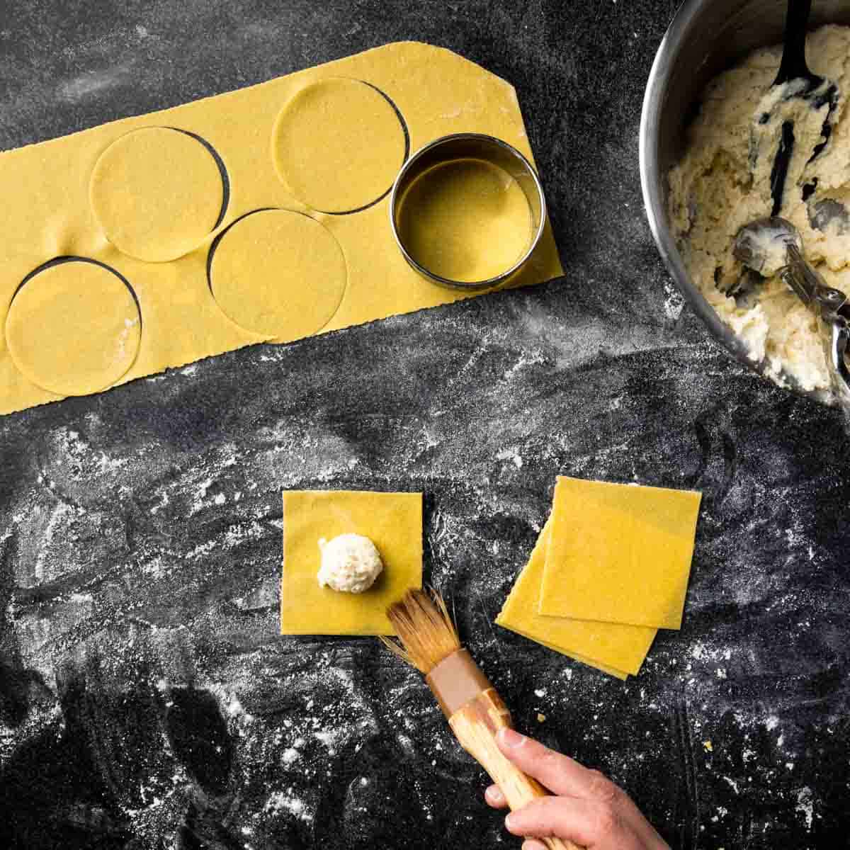 Cut circles and squares of pasta dough for ravioli.