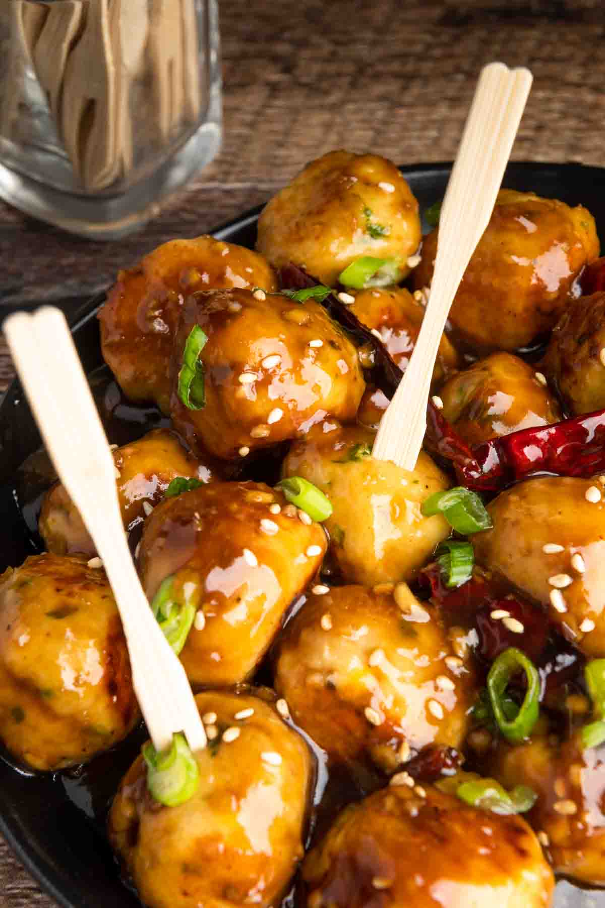A platter of General Tso meatballs with wooden picks.